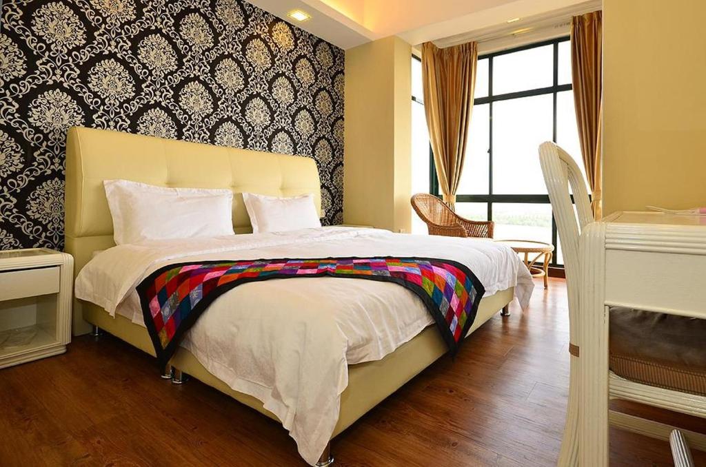 a bedroom with a bed with a colorful blanket on it at Jetty Suites Apartments in Malacca