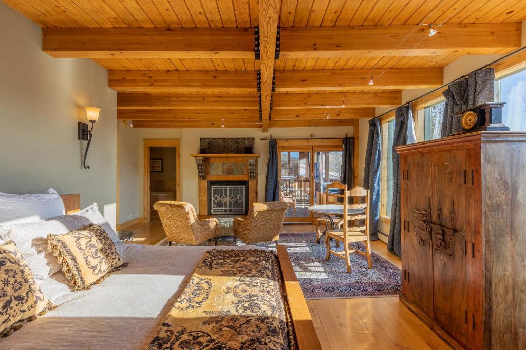 uma sala de estar com uma cama, uma mesa e cadeiras em Nordic Inn em Crested Butte