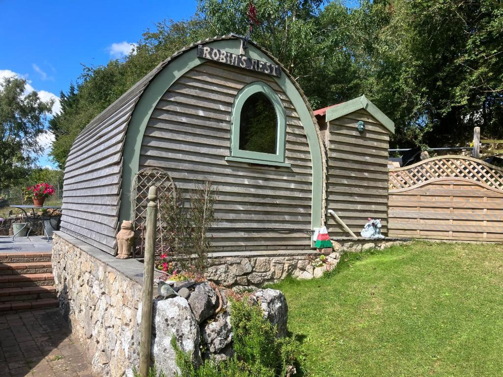 a small house with a window in a yard at Robins Nest glamping pod North Wales in Mold