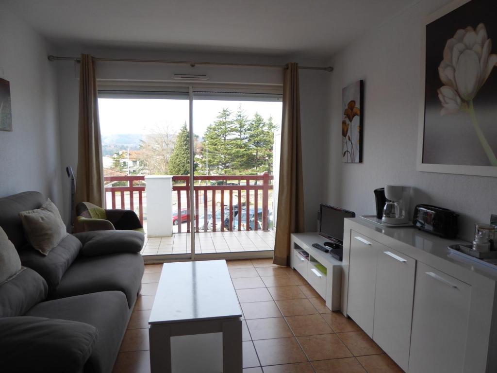 a living room with a couch and a balcony at Santiago in Hendaye