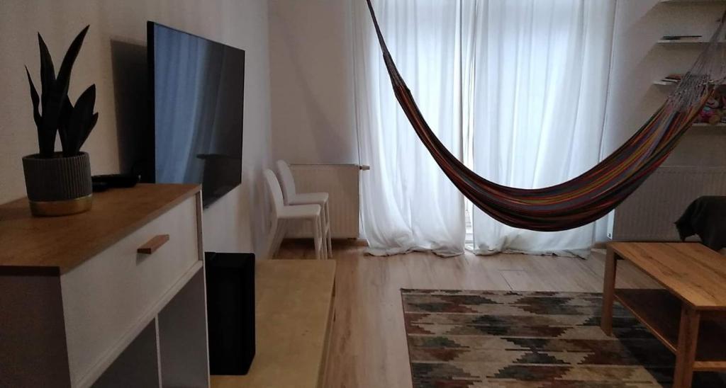 a living room with a hammock in front of a window at Mieszkanie z hamakiem in Gdańsk