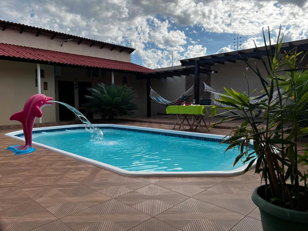 a swimming pool with a dolphin water fountain at Hotel Boutique Airla Seu Hotel em Casa in Boa Vista