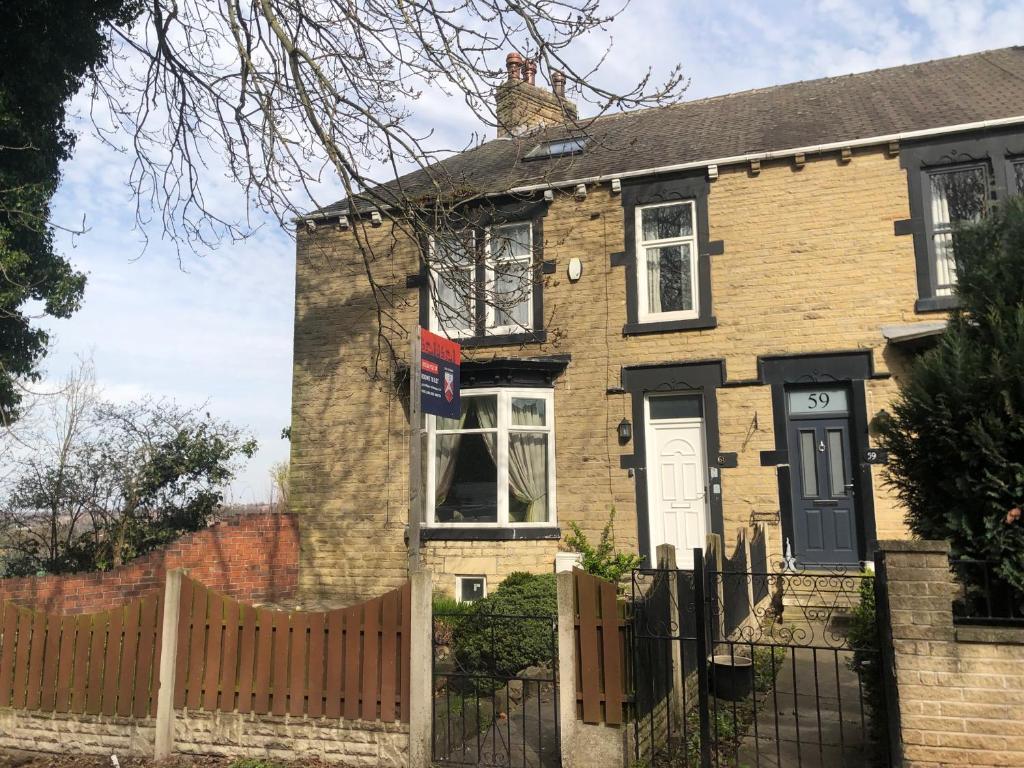 a brick house with a fence in front of it at 6 Bedroom Villa in Barnsley Centre in Barnsley