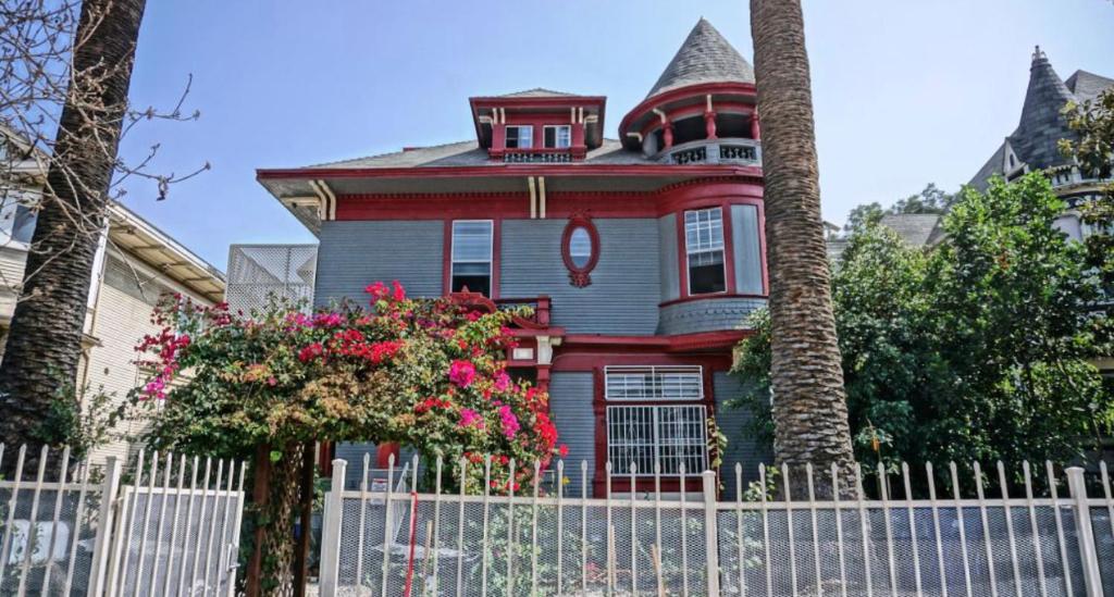 a red and gray house with a white fence at The Red Guest House in Downtown Los Angeles in Los Angeles