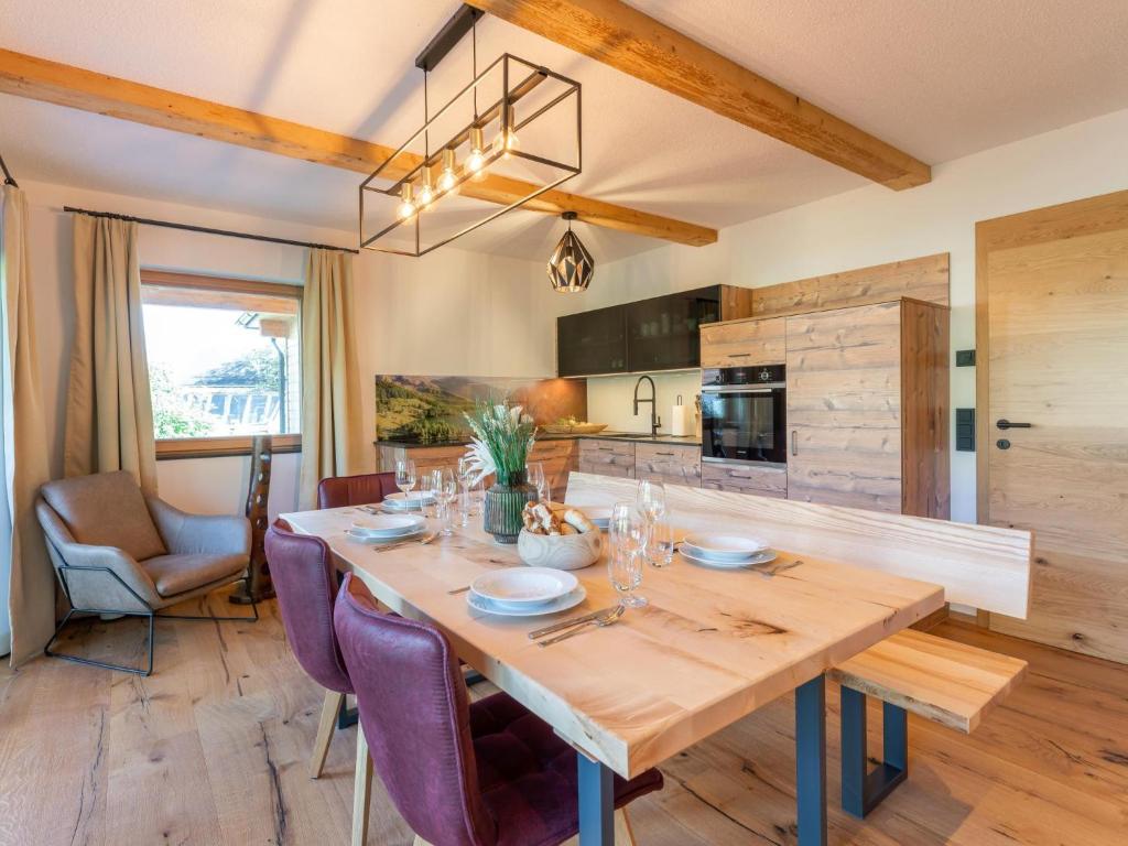 eine Küche und ein Esszimmer mit einem Holztisch und lila Stühlen in der Unterkunft AlmApARTment Mauterndorf Pichl 9-1 in Mauterndorf