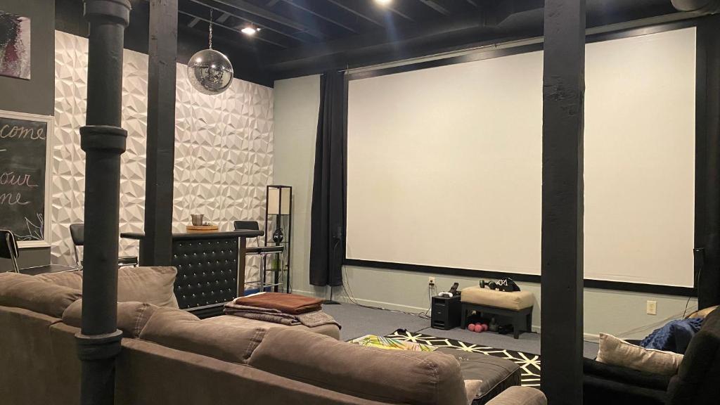 a room with two couches and a large projection screen at 160inch Home Movie Theater- Great for movie night! in Omaha