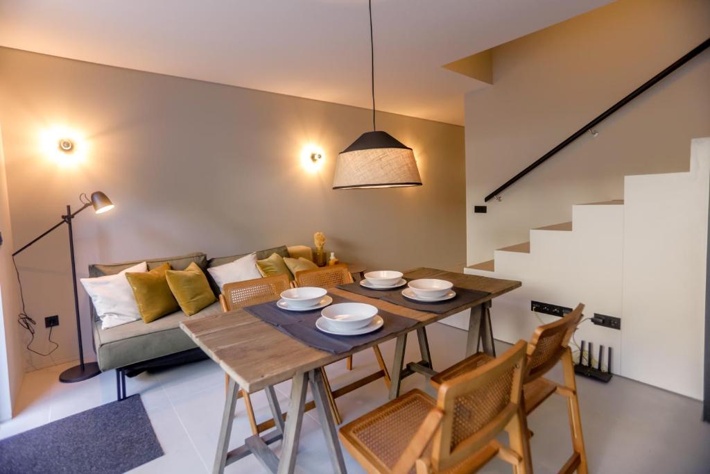a dining room with a table and a couch at Alegria Suítes By Porto City Hosts in Porto