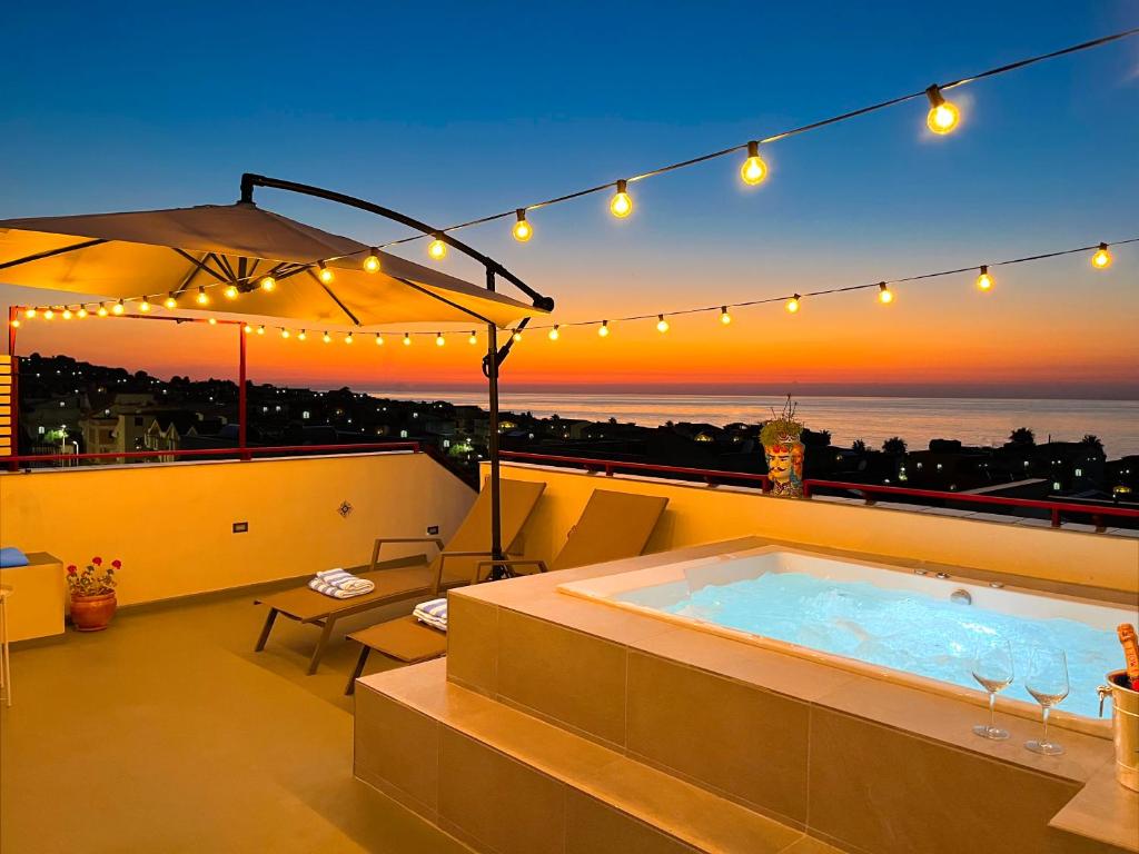 a hot tub on a balcony with a sunset at Duca d'Aosta Terrace, Skypool & Sauna in Acquedolci