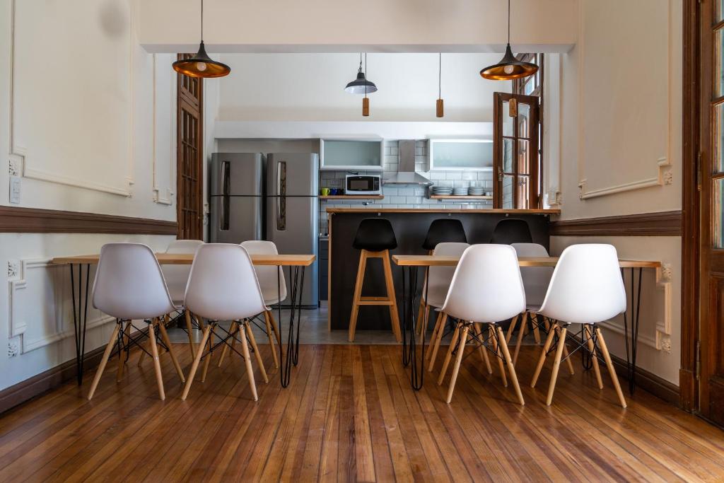 eine Küche mit weißen Stühlen und einem Holztisch in der Unterkunft Planta Alta BA in Buenos Aires