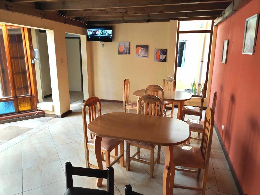 a dining room with tables and chairs and a television at El Ático Guatemala in Guatemala