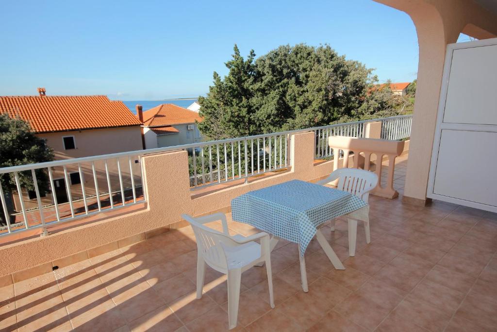 a patio with a table and chairs on a balcony at Double Room Mandre 3557b in Kolan