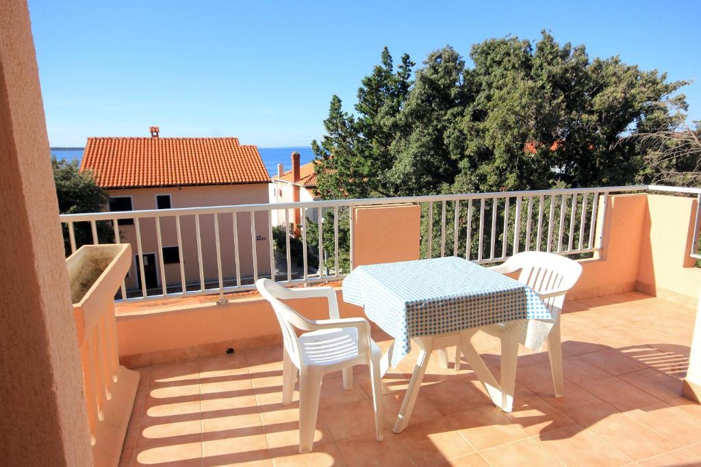 a patio with a table and chairs on a balcony at Double Room Mandre 3557a in Kolan