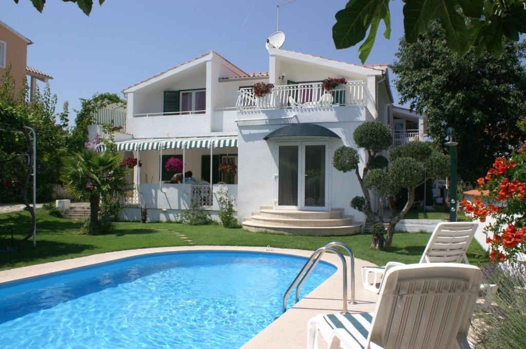 une villa avec une piscine en face d'une maison dans l'établissement Family friendly apartments with a swimming pool Vodice - 4235, à Vodice