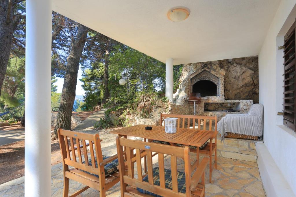 a patio with a table and chairs and a stone oven at Studio Balica Rat 1065a in Čelina