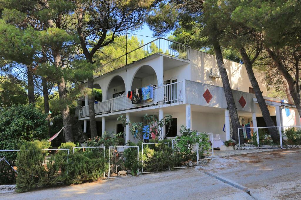 a white house with trees in front of it at Apartments by the sea Balica Rat, Omis - 1065 in Omiš