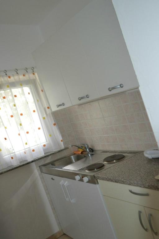 małą kuchnię ze zlewem i oknem w obiekcie Apartments by the sea Stara Novalja, Pag - 4106 w Novalji