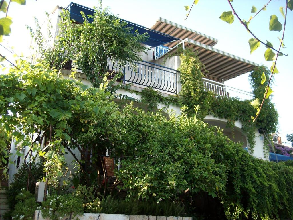 un bâtiment avec un balcon et des arbres devant lui dans l'établissement Apartments by the sea Seget Vranjica, Trogir - 2037, à Trogir