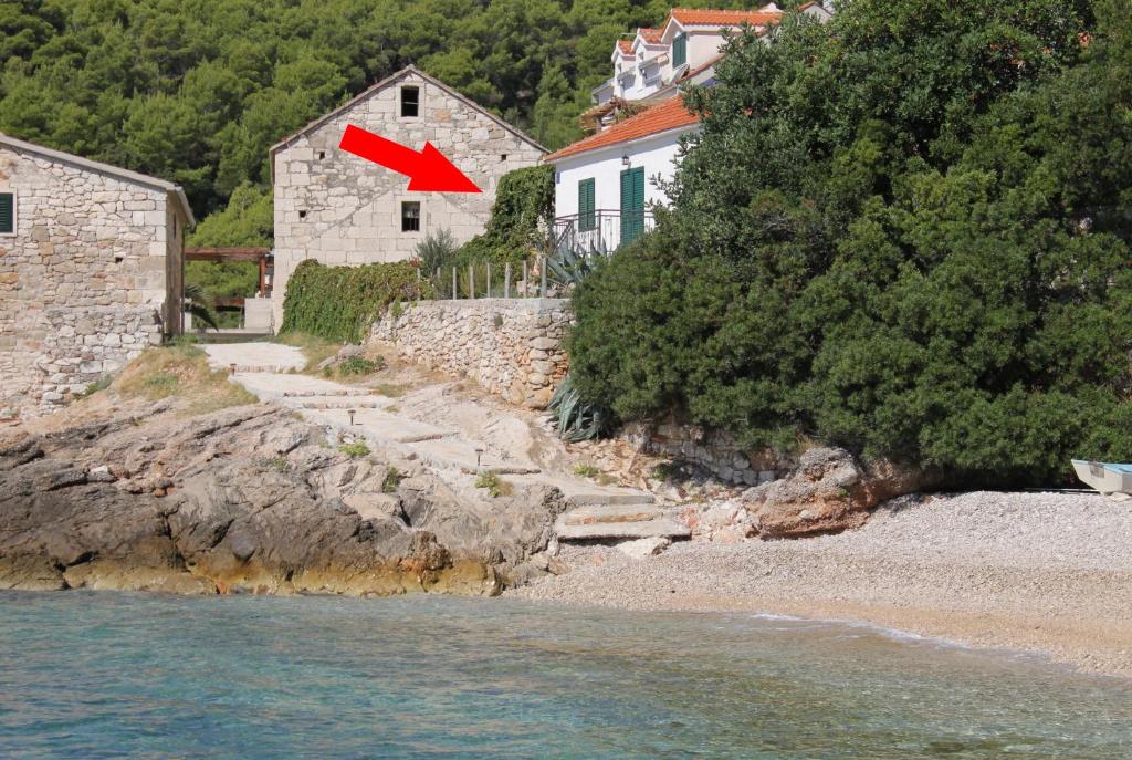 ein Haus mit einem roten Pfeil an der Seite eines Strandes in der Unterkunft Seaside house for families with children Cove Tvrdni Dolac, Hvar - 2057 in Gdinj