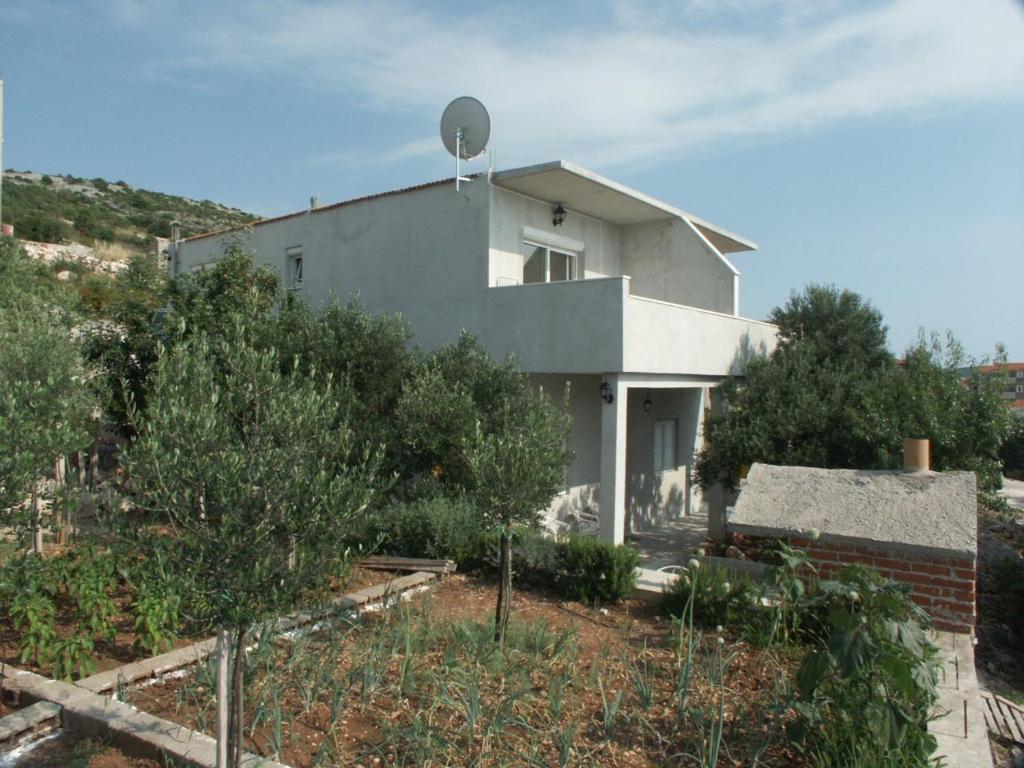 a white house with a antenna on top of it at Apartments by the sea Zatoglav, Rogoznica - 2094 in Podglavica