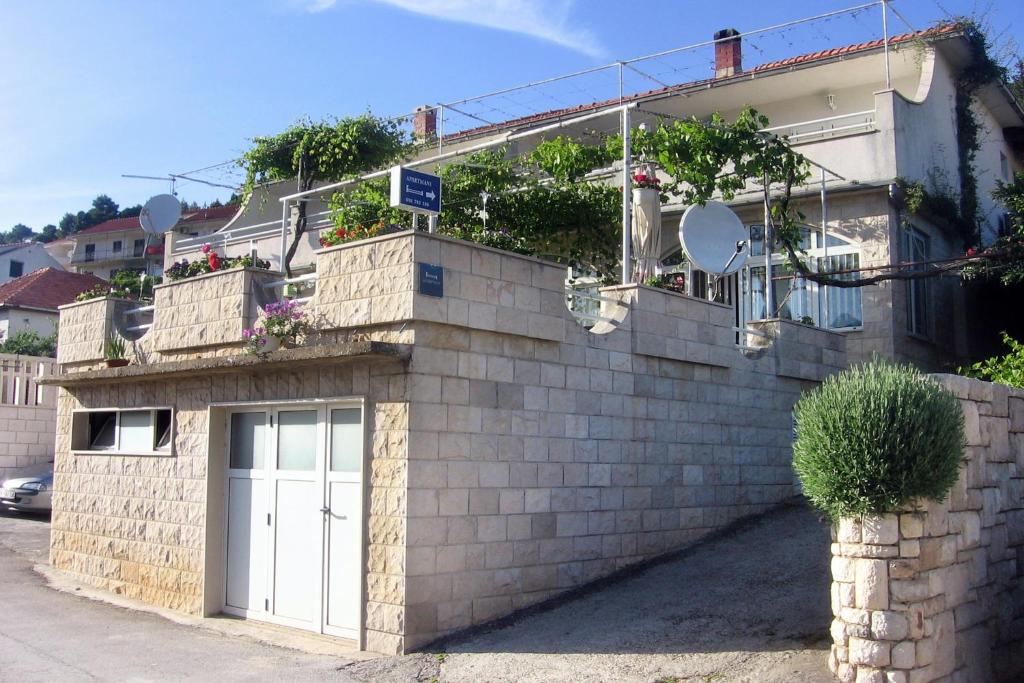 aige brick building with a white garage at Apartments with a parking space Jelsa, Hvar - 2059 in Jelsa