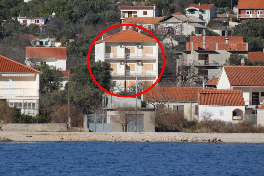 czerwony krąg na szczycie domu blisko wody w obiekcie Apartment Vinisce 1165b w mieście Vinišće