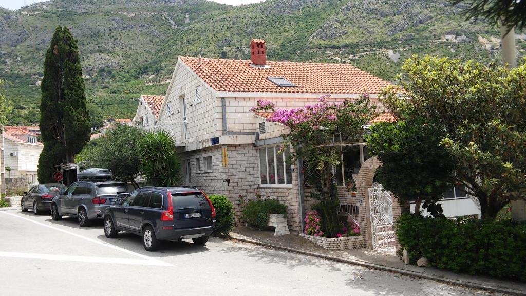 une maison avec des voitures garées sur le côté d&#39;une rue dans l&#39;établissement Apartments by the sea Plat, Dubrovnik - 2136, à Mlini