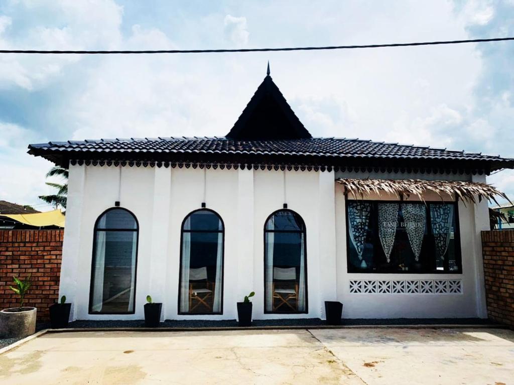 a white house with a black roof at Tamu Beradu Seaview Private Pool Villa in Dungun