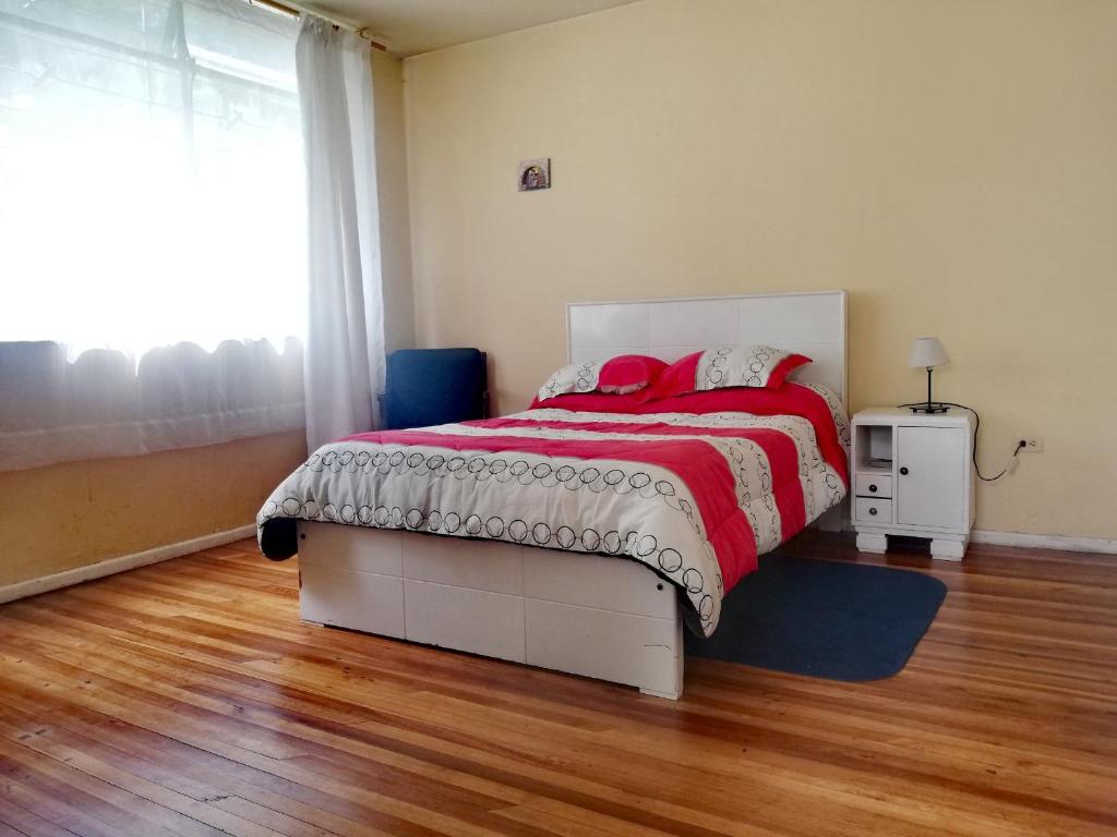 1 dormitorio con 1 cama con manta roja y blanca en Fully Equipped Appartment in Quito Centre, en Quito