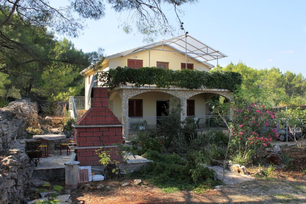 a house with a brick chimney in a garden at Apartments with a parking space Mudri Dolac, Hvar - 4043 in Vrbanj