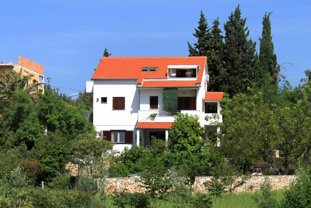 ein weißes Haus mit orangefarbenem Dach in der Unterkunft Apartments with a swimming pool Stari Grad, Hvar - 4015 in Stari Grad