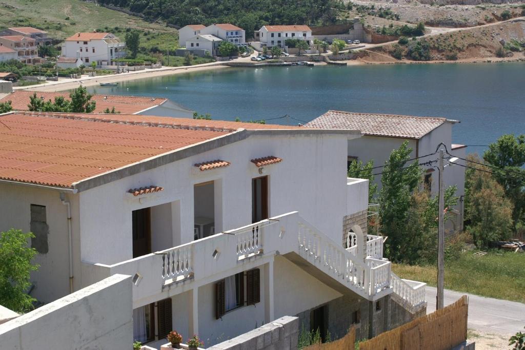 ein weißes Haus mit Blick auf einen Wasserkörper in der Unterkunft Apartment Metajna 4150b in Metajna