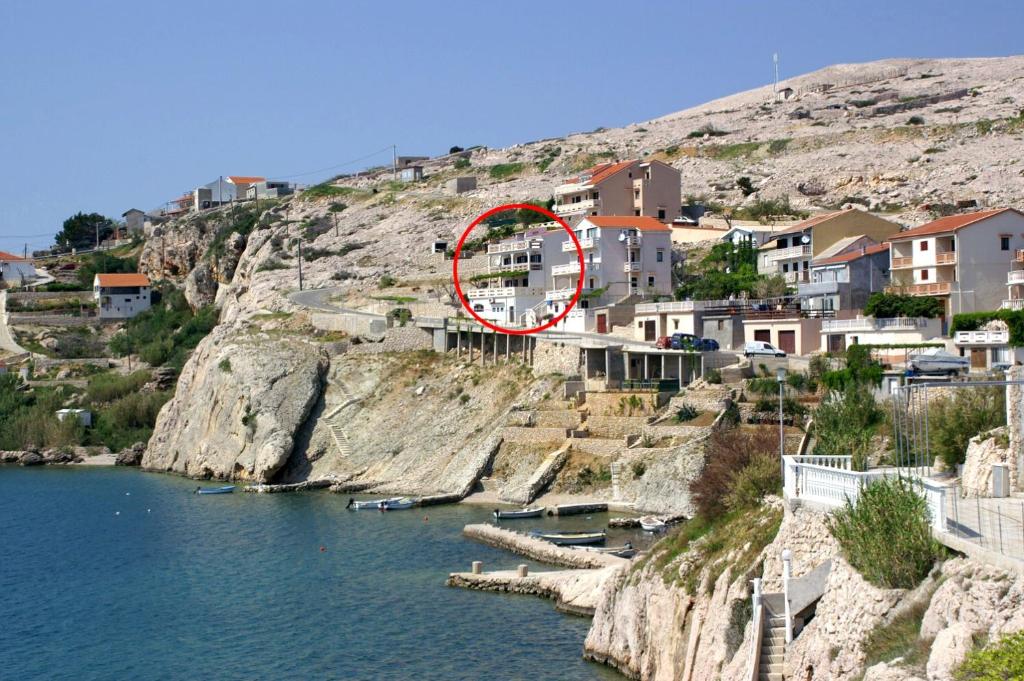 un edificio su una collina vicino a un corpo d'acqua di Apartments and rooms by the sea Zubovici, Pag - 4065 a Zubovići