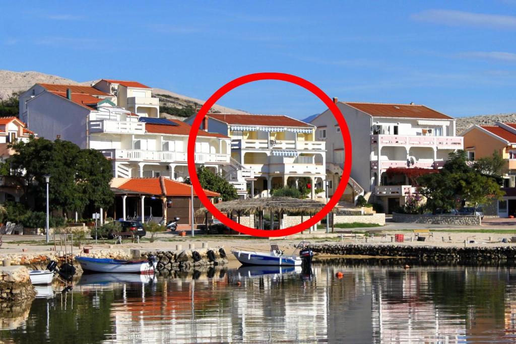 a group of birds sitting in the water in front of buildings at Apartments by the sea Kustici, Pag - 4129 in Kustići