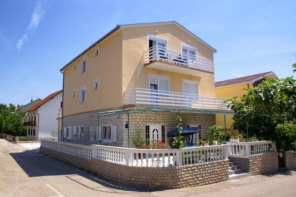 ein großes Haus mit einem weißen Zaun davor in der Unterkunft Studio Vodice 4172a in Vodice
