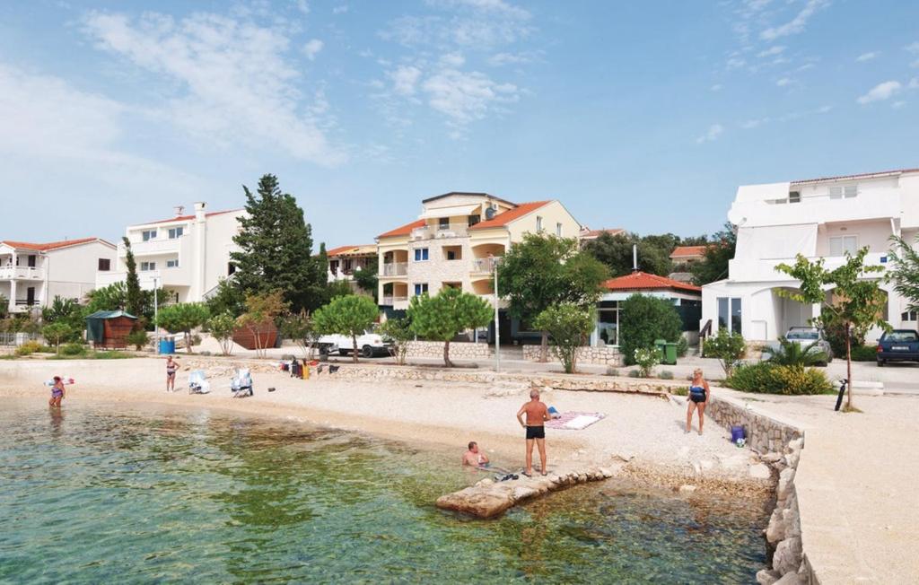 eine Gruppe von Menschen an einem Strand in der Nähe des Wassers in der Unterkunft Apartments by the sea Mandre, Pag - 4092 in Kolan