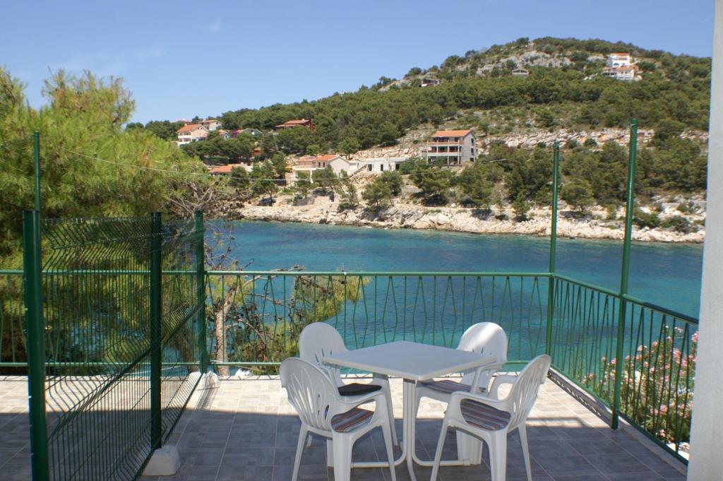 a table and chairs on a balcony with a view of the water at Apartment Bilo 4189b in Podgreben