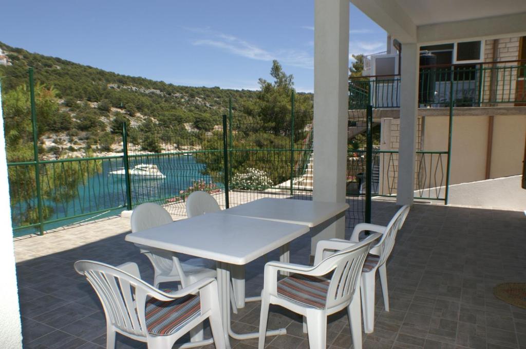 a table and chairs on a balcony with a view of the water at Apartment Bilo 4189a in Podgreben