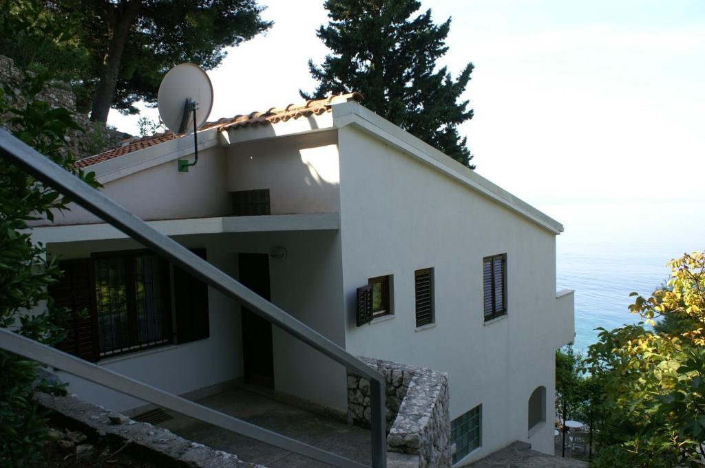 a house on the side of a hill at Apartments by the sea Nemira, Omis - 4277 in Tice