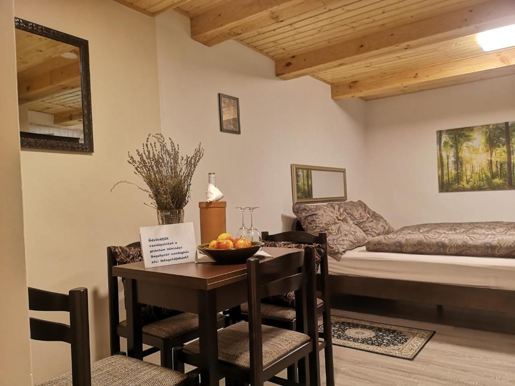 Habitación con mesa y cama en Bagolyvár vendégház, en Magyarszombatfa