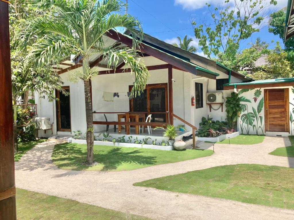 a house with a palm tree in front of it at Casa De Loren in General Luna