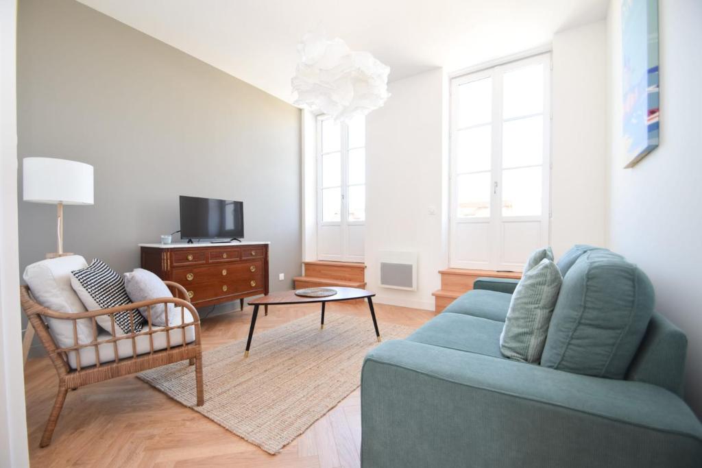 sala de estar con sofá azul y silla en Appt 3 pièces haut de gamme dans la " Villa Hortense" à 200 m plage, en Dinard