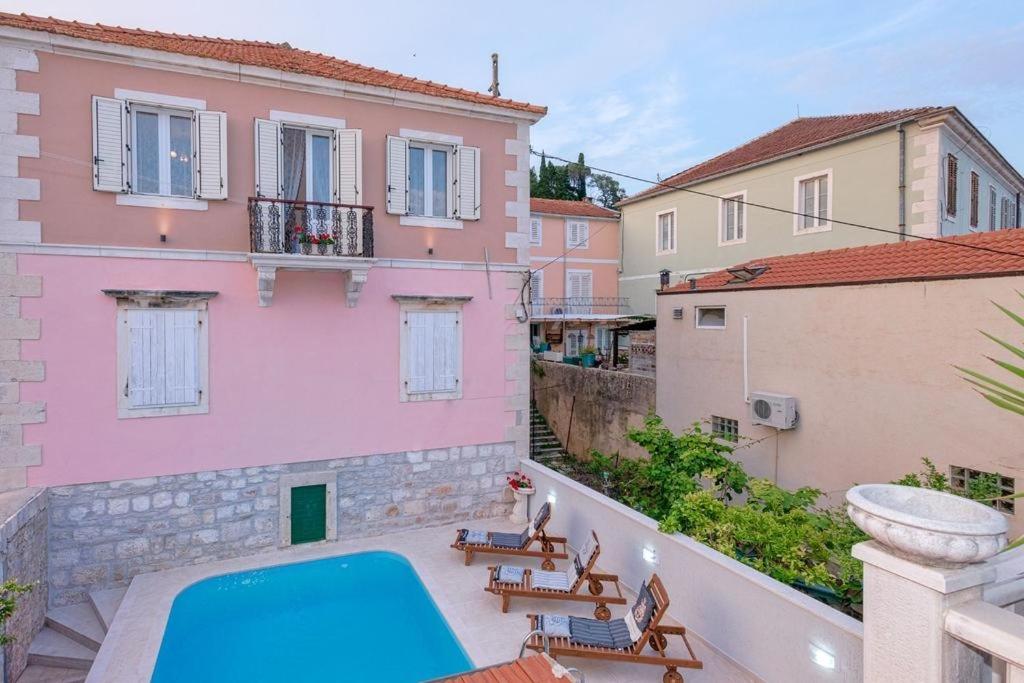 イェルサにあるSeaside apartments with a swimming pool Jelsa, Hvar - 2067のバルコニーからスイミングプール付きの家の景色を望めます。