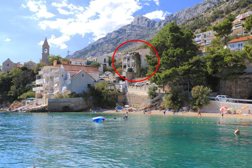 een groep mensen op een strand in het water bij Apartments by the sea Pisak, Omis - 1067 in Pisak