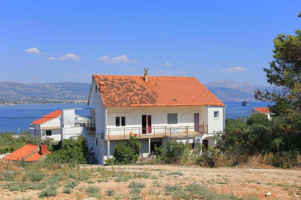 duży biały dom z pomarańczowym dachem w obiekcie Apartments and rooms by the sea Arbanija, Ciovo - 1125 w Trogirze