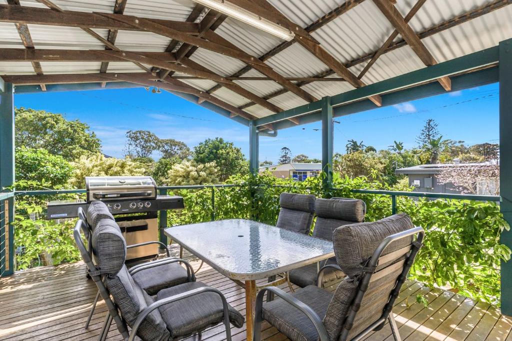 a patio with a table and chairs on a deck at Bayhaven in Iluka