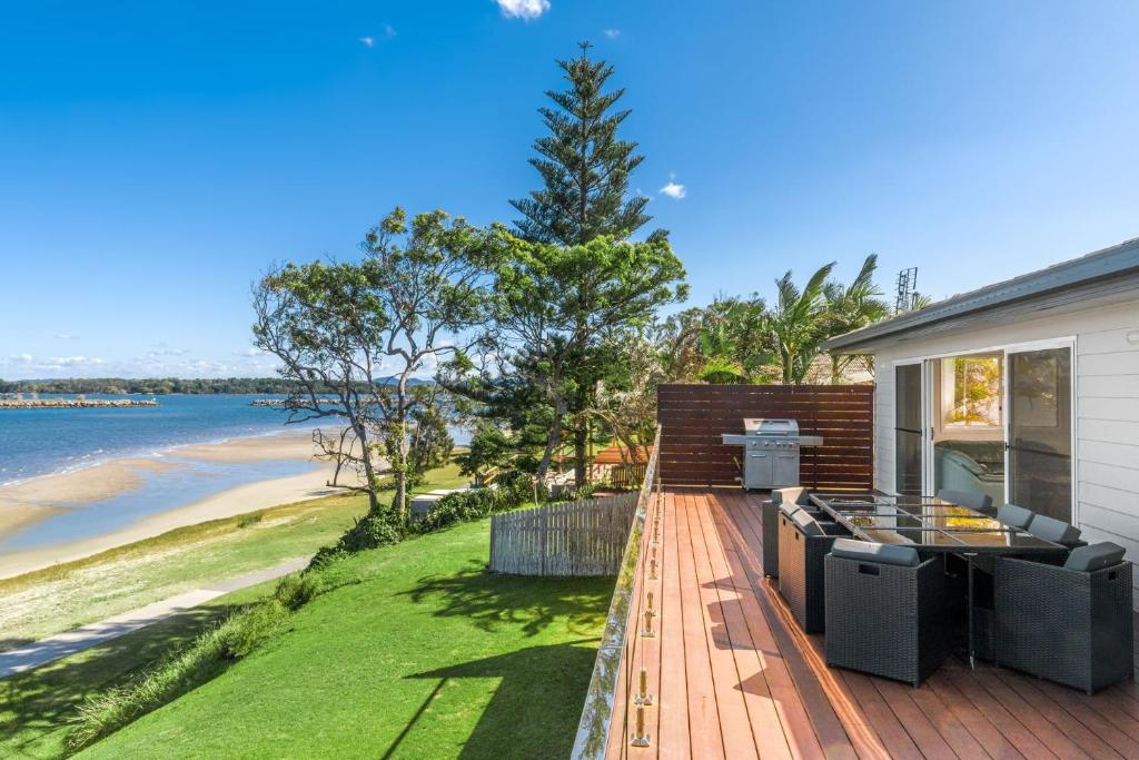 a house with a deck with a view of the ocean at Omaroo Prestige Waterfront in Iluka
