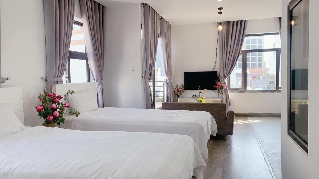 a hotel room with two beds and a television at 5A - Pool seaview Blue Sea Apartment in Da Nang
