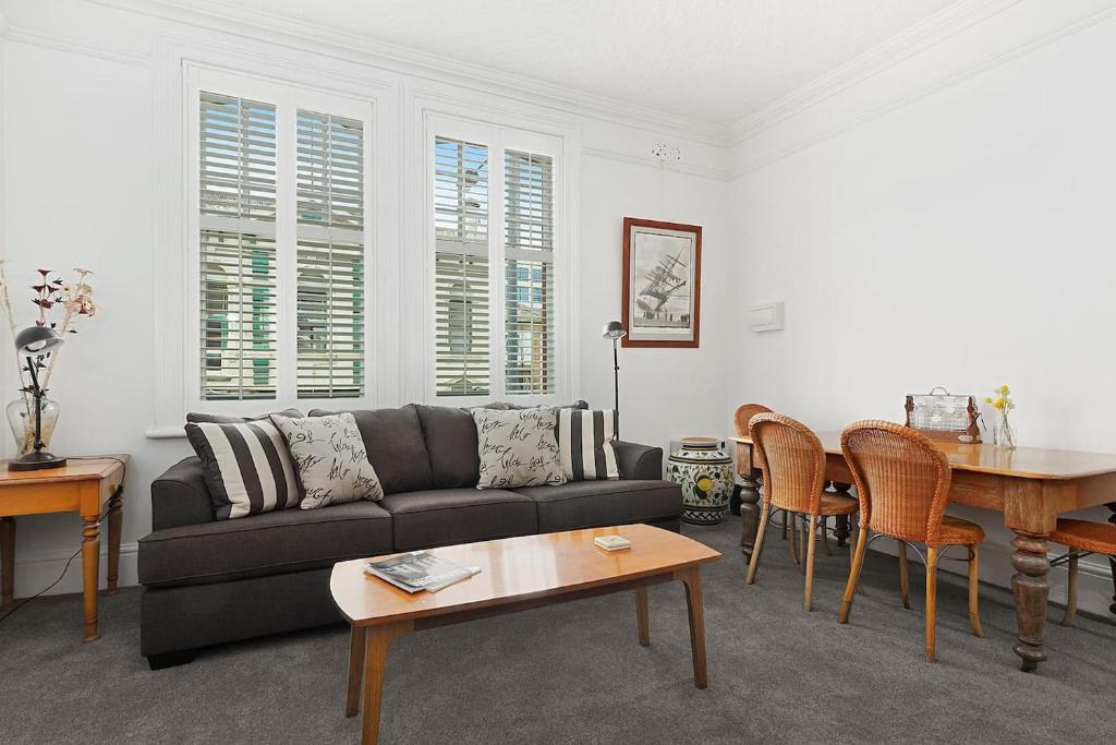 uma sala de estar com um sofá e uma mesa em Fabulous 2 level city pad in historic building em Hobart