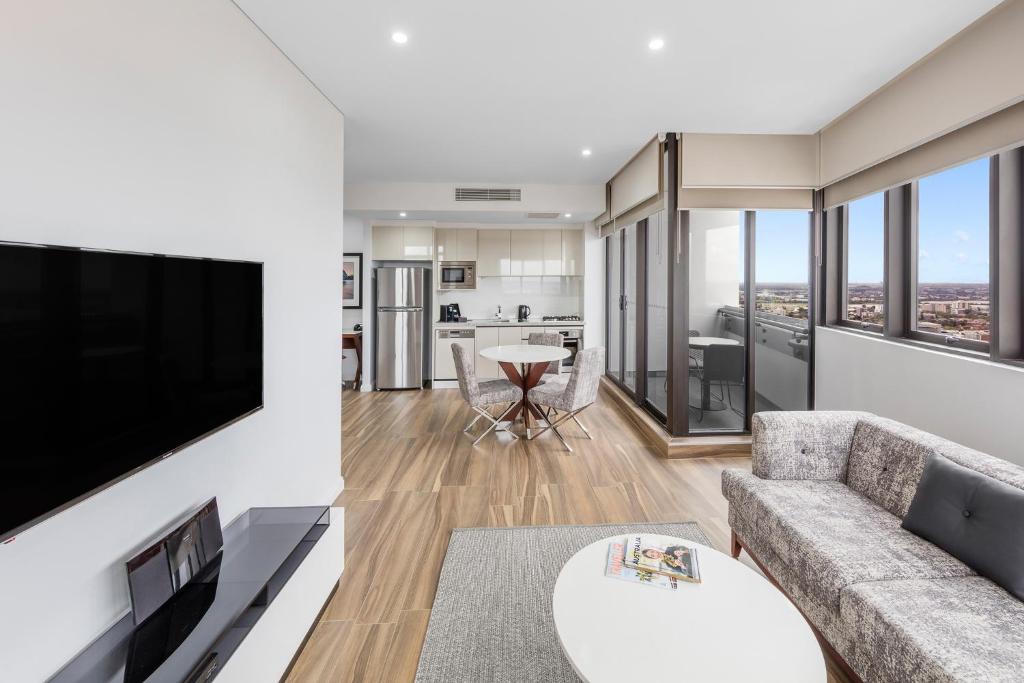 雪梨的住宿－帕拉馬塔教堂街美利通公寓式酒店，带沙发和平面电视的客厅