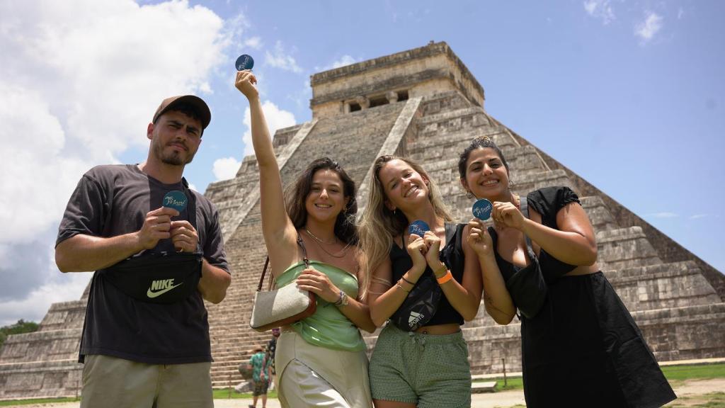 Maui Hostels Playa del Carmen في بلايا ديل كارمن: مجموعة أشخاص واقفين أمام الهرم